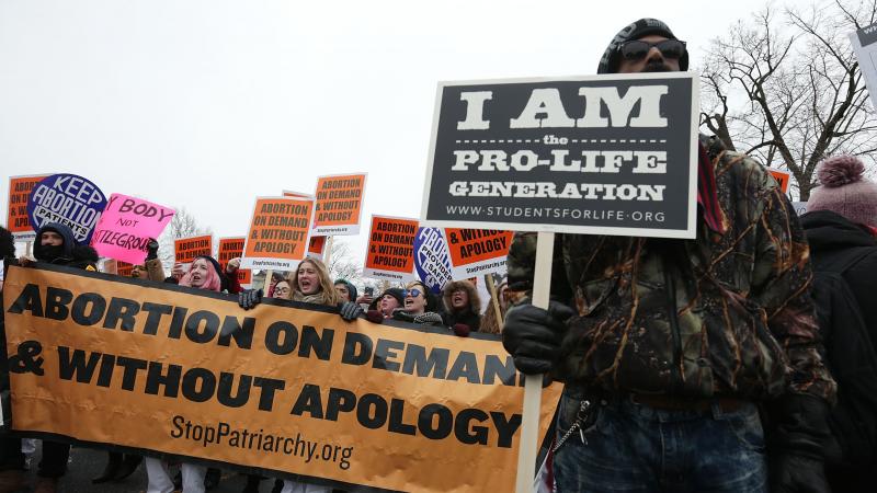 Protesters spread their dueling messages at a March for Life rally in 2016. Only 17 percent of Americans say they want the landmark Roe v. Wade ruling overturned, a new NPR/PBS NewsHour/Marist poll finds. Protesters spread their dueling messages at a March for Life rally in 2016. Only 17 percent of Americans say they want the landmark Roe v. Wade ruling overturned, a new NPR/PBS NewsHour/Marist poll finds.