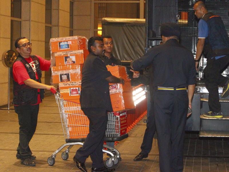 Police prepare to load confiscated items into a truck in Kuala Lumpur, Malaysia on Friday after a raid on a condominium belonging to former Prime Minister Najib Razak. Police prepare to load confiscated items into a truck in Kuala Lumpur, Malaysia on Friday after a raid on a condominium belonging to former Prime Minister Najib Razak.