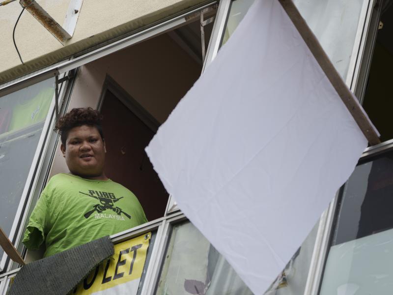 Mohamad Nor Abdullah, born without arms, looks out from a window near a white flag outside the window of his rented room in Kuala Lumpur, Malaysia on July 3. When Mohamad Nor put a white flag outside his window late at night, he didn't expect the swift ou Mohamad Nor Abdullah, born without arms, looks out from a window near a white flag outside the window of his rented room in Kuala Lumpur, Malaysia on July 3. When Mohamad Nor put a white flag outside his window late at night, he didn't expect the swift ou