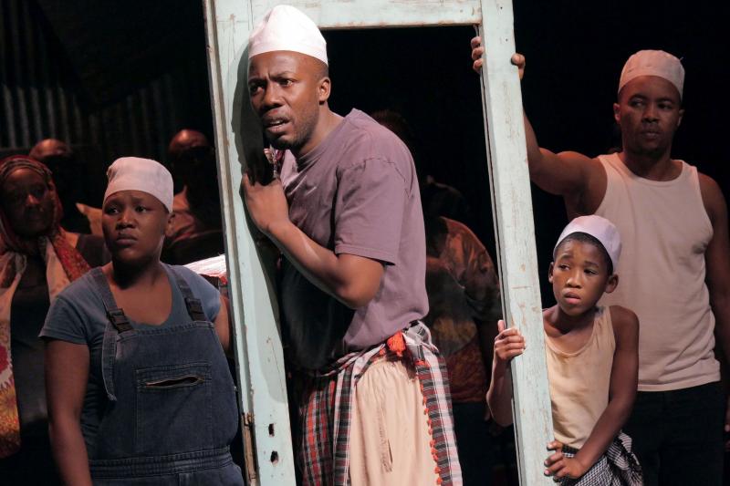 Somali refugee Asad Abdullahi is played by four different actors, each wearing the same white hat: (left to right) Zoleka Mpotsha, Ayanda Tikolo, Siphosethu Juta and Luvo Tamba. Somali refugee Asad Abdullahi is played by four different actors, each wearing the same white hat: (left to right) Zoleka Mpotsha, Ayanda Tikolo, Siphosethu Juta and Luvo Tamba.