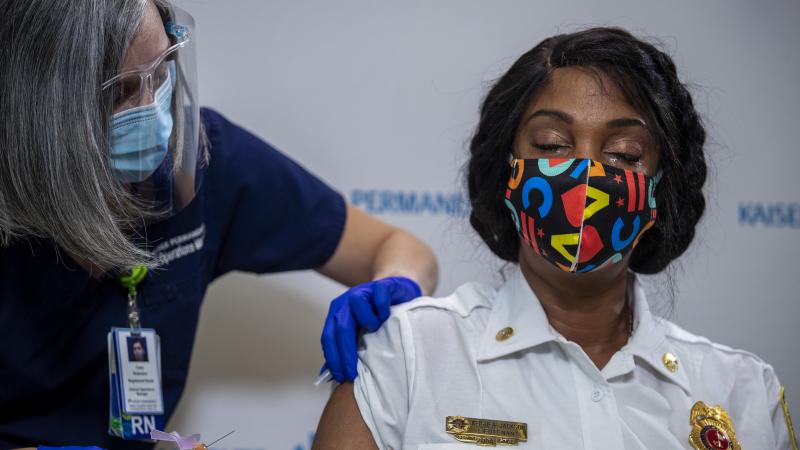 Washington, D.C., Fire and EMS Lt. Keishea Jackson gets a Pfizer coronavirus vaccine shot on Thursday. Washington, D.C., Fire and EMS Lt. Keishea Jackson gets a Pfizer coronavirus vaccine shot on Thursday.