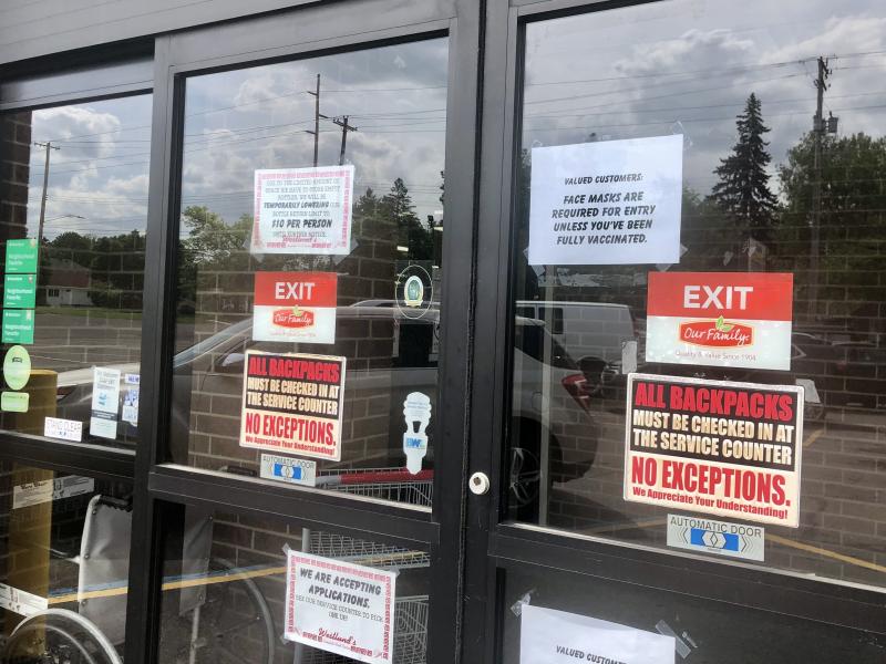 A sign on the front doors of Westlund's Apple Market in Lansing, Mich., asks customers to wear a mask unless they are vaccinated against COVID-19. A sign on the front doors of Westlund's Apple Market in Lansing, Mich., asks customers to wear a mask unless they are vaccinated against COVID-19.