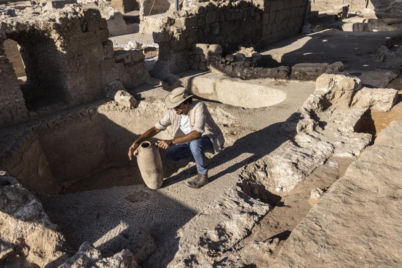 Avshalom Davidesko, from the Israel's Antiquities Authority, examines a jar in a massive ancient winemaking complex dating back some 1,500 years in Yavne, south of Tel Aviv, Israel. Avshalom Davidesko, from the Israel's Antiquities Authority, examines a jar in a massive ancient winemaking complex dating back some 1,500 years in Yavne, south of Tel Aviv, Israel.