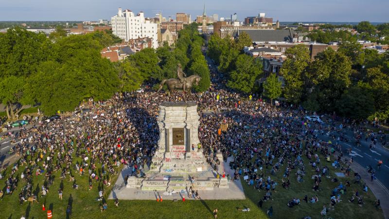 A large group of protesters gathered around the statue of Confederate Gen. Robert E. Lee, on Tuesday in Richmond, Va. The crowd protesting police brutality chanted, "Tear it down." A large group of protesters gathered around the statue of Confederate Gen. Robert E. Lee, on Tuesday in Richmond, Va. The crowd protesting police brutality chanted, "Tear it down."