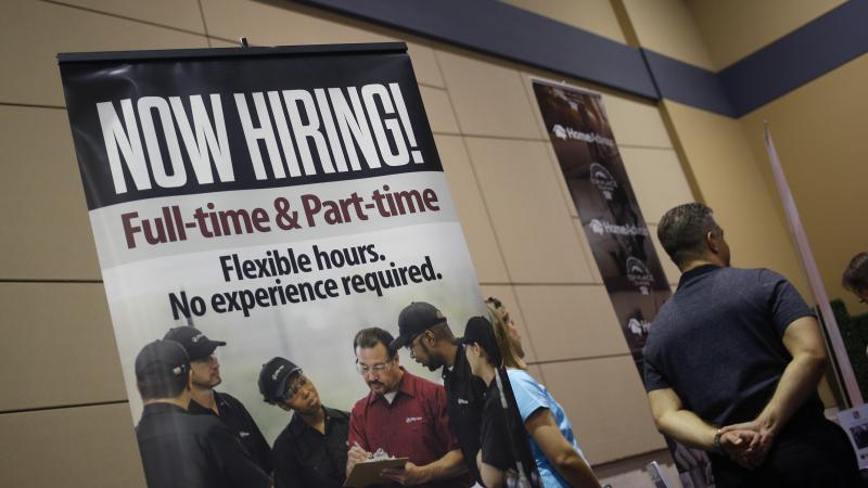 A "Now Hiring!" sign is displayed next to the Jiffy Lube International booth at a jobs fair in Overland Park, Kan., in March. A "Now Hiring!" sign is displayed next to the Jiffy Lube International booth at a jobs fair in Overland Park, Kan., in March.
