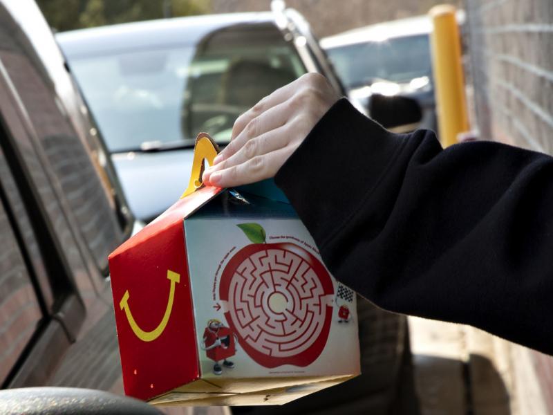 McDonald's says it will phase out most plastic from its Happy Meals by 2025. Here, a customer picks up a kid's meal at a McDonald's drive-through. McDonald's says it will phase out most plastic from its Happy Meals by 2025. Here, a customer picks up a kid's meal at a McDonald's drive-through.