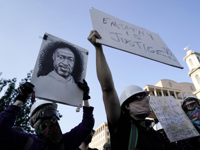 A demonstrator holds a sign with George Floyd's likeness on it as people gather to protest his death and police brutality this week near the White House in Washington. A demonstrator holds a sign with George Floyd's likeness on it as people gather to protest his death and police brutality this week near the White House in Washington.
