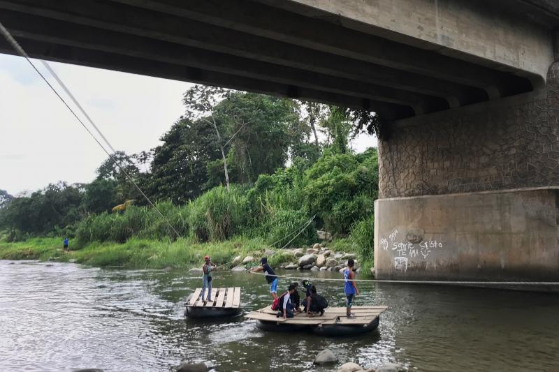 Migrants and day laborers cross the Suchiate River, which divides Mexico and Guatemala. The crossing happens despite immigration officials working on the bridge above. Migrants and day laborers cross the Suchiate River, which divides Mexico and Guatemala. The crossing happens despite immigration officials working on the bridge above.