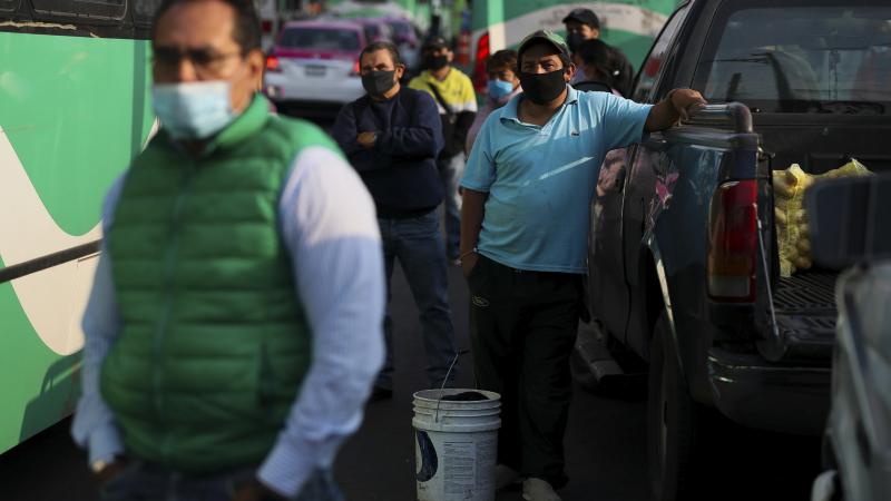 Commuters wait to board buses in Mexico City on Monday. Commuters wait to board buses in Mexico City on Monday.