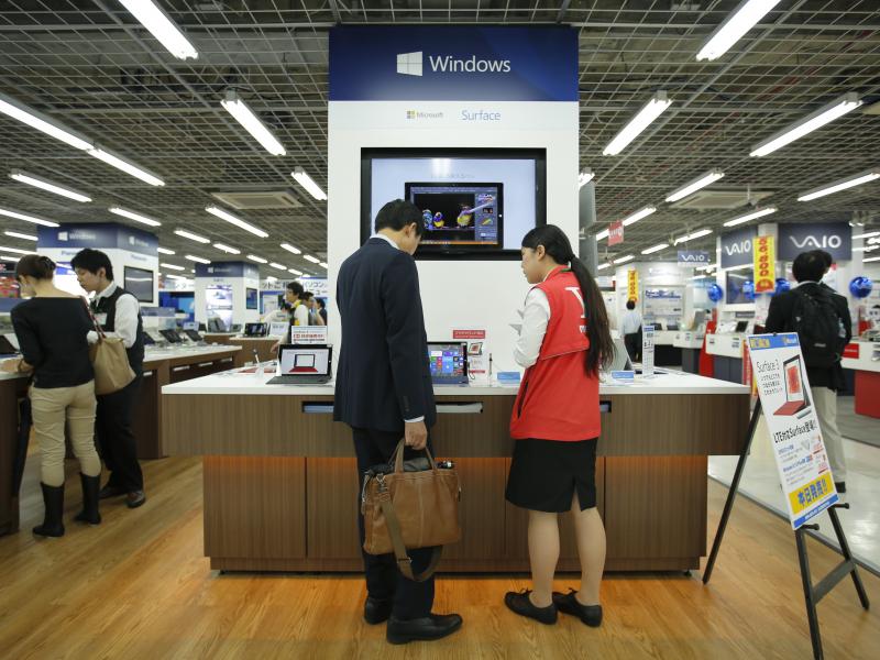 A sales clerk speaks with a customer in front of Microsoft Corp.'s display at an electronics store in Tokyo. Microsoft's division in Japan says it saw productivity grow by 40% after allowing employees to work for four days a week rather than five. A sales clerk speaks with a customer in front of Microsoft Corp.'s display at an electronics store in Tokyo. Microsoft's division in Japan says it saw productivity grow by 40% after allowing employees to work for four days a week rather than five.
