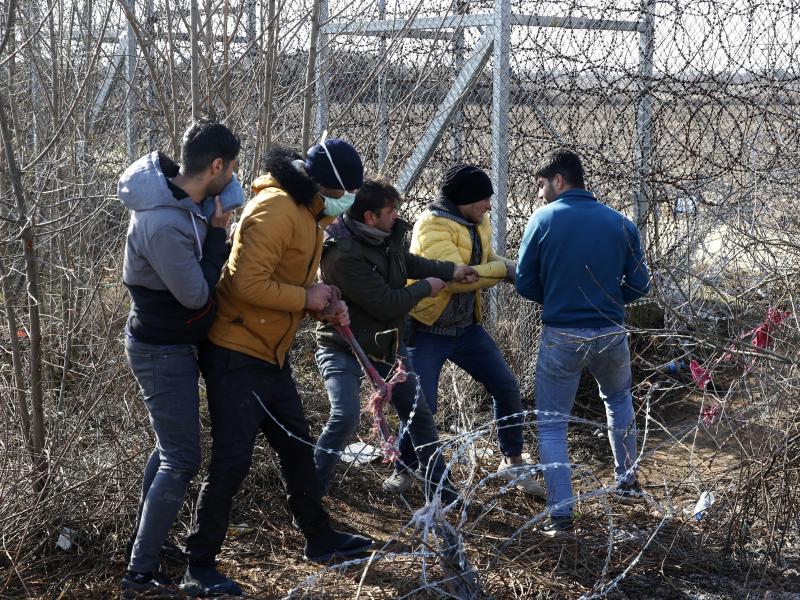 Migrants try to cut the fence at the Turkish-Greek border near the Pazarkule border gate in Edirne, Turkey, on Monday. Thousands of migrants and refugees massed at Turkey's western frontier, trying to enter Greece by land and sea after Turkey said its bor Migrants try to cut the fence at the Turkish-Greek border near the Pazarkule border gate in Edirne, Turkey, on Monday. Thousands of migrants and refugees massed at Turkey's western frontier, trying to enter Greece by land and sea after Turkey said its bor