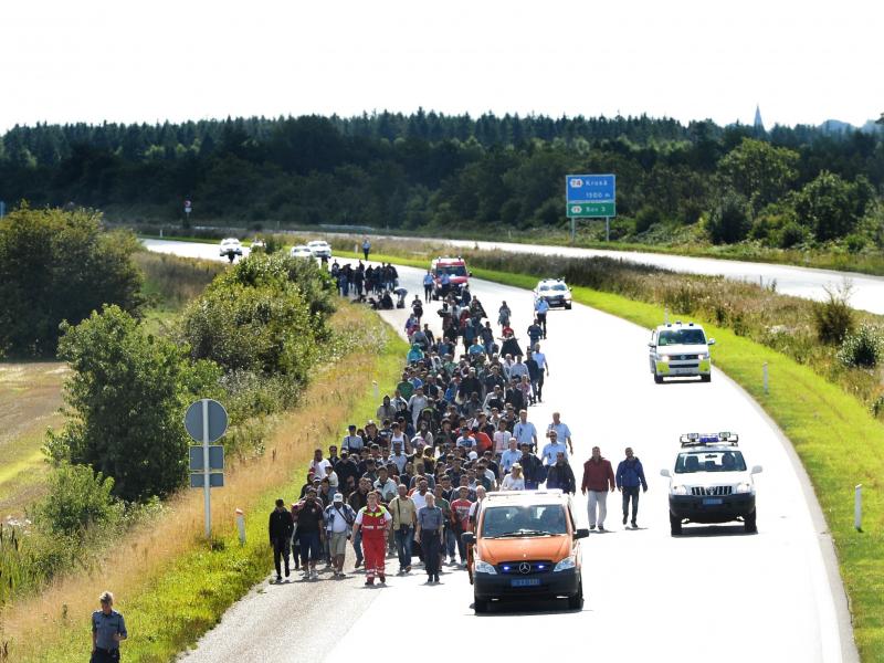Migrants, mostly from Syria and Iraq, set out on foot along a highway on the Danish-German border, heading north to Sweden on Wednesday. They arrived that morning on a train from Germany. Migrants, mostly from Syria and Iraq, set out on foot along a highway on the Danish-German border, heading north to Sweden on Wednesday. They arrived that morning on a train from Germany.