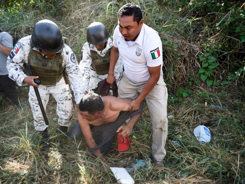Members of the Mexican National Guard and officers of the Migration Institute detain a Central American migrant heading in a caravan to the U.S. in Ciudad Hidalgo, Chiapas State, Mexico, on Jan. 23. Members of the Mexican National Guard and officers of the Migration Institute detain a Central American migrant heading in a caravan to the U.S. in Ciudad Hidalgo, Chiapas State, Mexico, on Jan. 23.