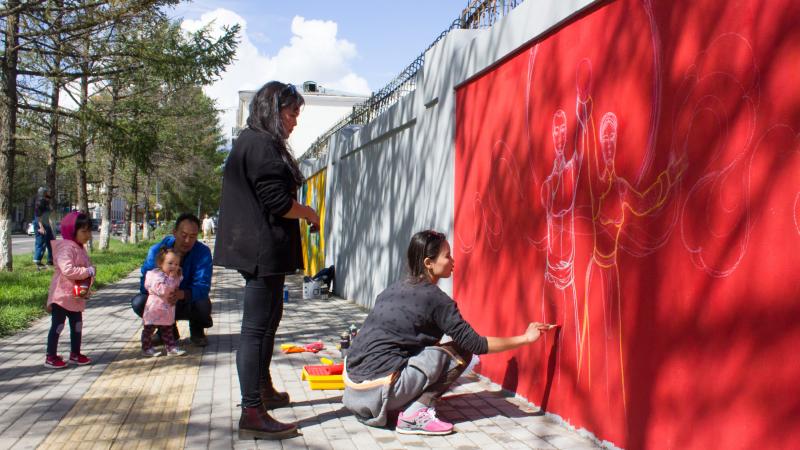 They're the only two female artists working on a Mongolian street mural about the U.N. Sustainable Development Goals: Michid Enkhbat (stooping) and Odno Bold. The goal they're illustrating: "gender equality." They're the only two female artists working on a Mongolian street mural about the U.N. Sustainable Development Goals: Michid Enkhbat (stooping) and Odno Bold. The goal they're illustrating: "gender equality."