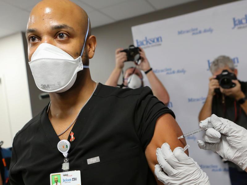 Dr. Hansel Tookes made sure his first dose of Pfizer's COVID-19 vaccine at Jackson Memorial Hospital in Miami on Dec. 15. was televised, as a way to combat hesitancy. Dr. Hansel Tookes made sure his first dose of Pfizer's COVID-19 vaccine at Jackson Memorial Hospital in Miami on Dec. 15. was televised, as a way to combat hesitancy.