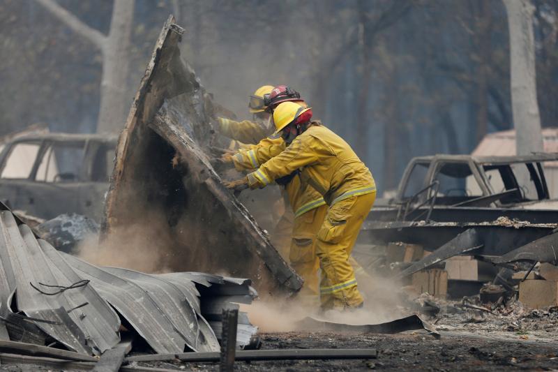 Cal Fire firefighters comb through a house destroyed by the Camp Fire in Paradise, Calif., on Tuesday. Cal Fire firefighters comb through a house destroyed by the Camp Fire in Paradise, Calif., on Tuesday.