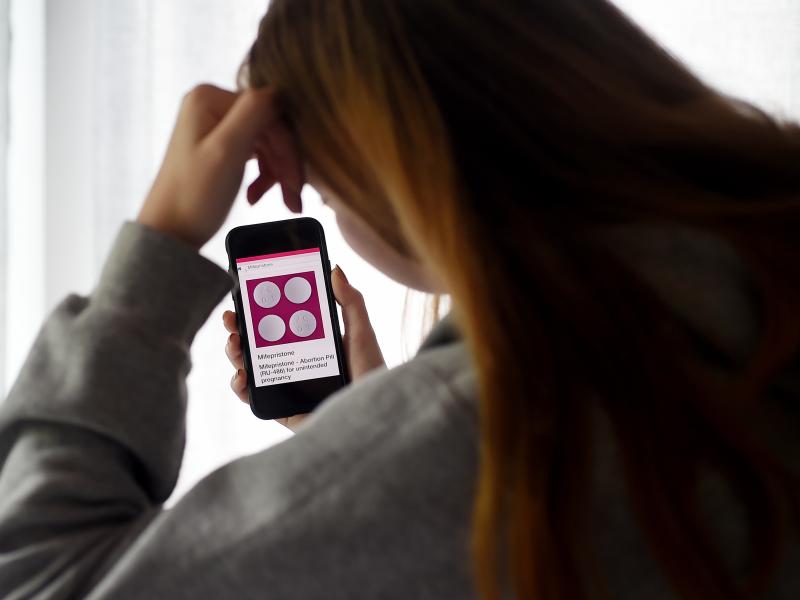 In this photo illustration, a person looks at an abortion pill (RU-486) for unintended pregnancy from Mifepristone displayed on a smartphone on May 8, 2020, in Arlington, Va. Under federal law, even in states where telemedicine abortion is legal, there ar In this photo illustration, a person looks at an abortion pill (RU-486) for unintended pregnancy from Mifepristone displayed on a smartphone on May 8, 2020, in Arlington, Va. Under federal law, even in states where telemedicine abortion is legal, there ar
