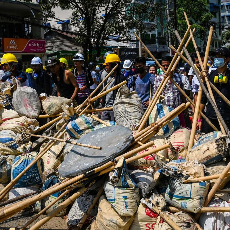 Protesters take cover behind makeshift barricades during a demonstration against the military coup in Yangon's Thaketa township on Friday. Protesters take cover behind makeshift barricades during a demonstration against the military coup in Yangon's Thaketa township on Friday.