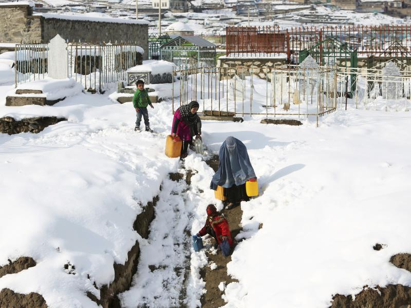 A woman and her children carry containers of water on the outskirts of Kabul, Afghanistan, on Monday. Avalanches have killed more than 100 people in Afghanistan and Pakistan. A woman and her children carry containers of water on the outskirts of Kabul, Afghanistan, on Monday. Avalanches have killed more than 100 people in Afghanistan and Pakistan.