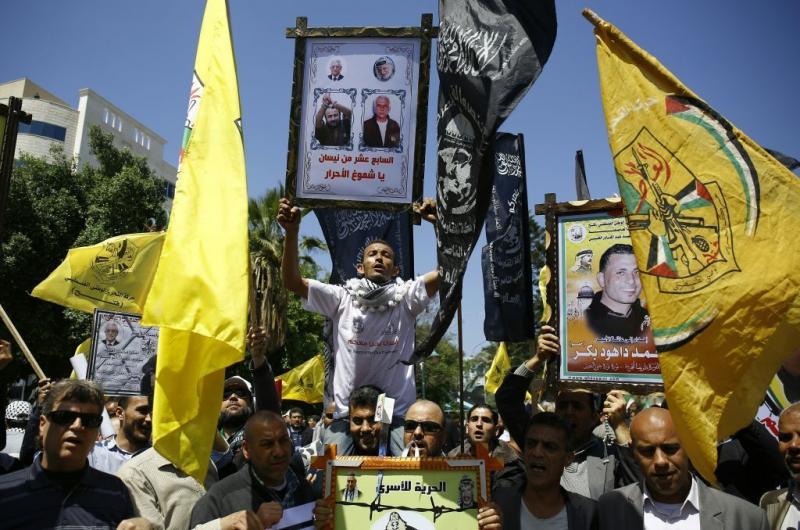 Protesters hold up portraits of Palestinians detained in Israeli jails during a demonstration in Gaza City to show support to the prisoners who launched a hunger strike on Monday. Protesters hold up portraits of Palestinians detained in Israeli jails during a demonstration in Gaza City to show support to the prisoners who launched a hunger strike on Monday.