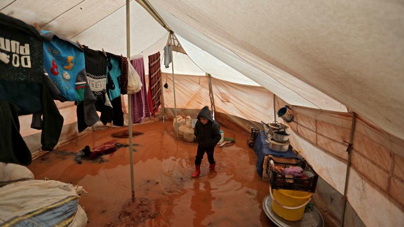 A child walks inside a flooded tent at a camp for the displaced people near Bab al-Hawa by the border with Turkey, in Syria's northwestern Idlib province, on Monday. A child walks inside a flooded tent at a camp for the displaced people near Bab al-Hawa by the border with Turkey, in Syria's northwestern Idlib province, on Monday.