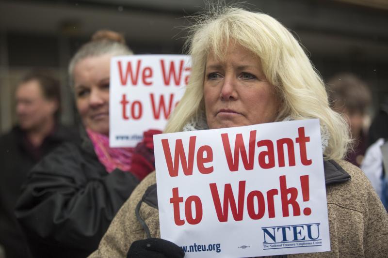 IRS employee Pam Crosbie and others hold signs protesting the government shutdown at a federal building in Ogden, Utah. IRS employee Pam Crosbie and others hold signs protesting the government shutdown at a federal building in Ogden, Utah.
