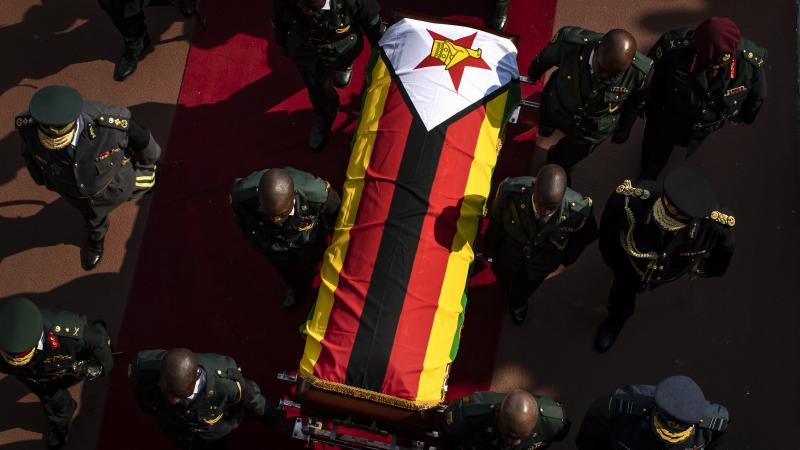 Military officers carry the casket of former president Robert Mugabe out of his state funeral at the National Sports Stadium in Harare. Military officers carry the casket of former president Robert Mugabe out of his state funeral at the National Sports Stadium in Harare.