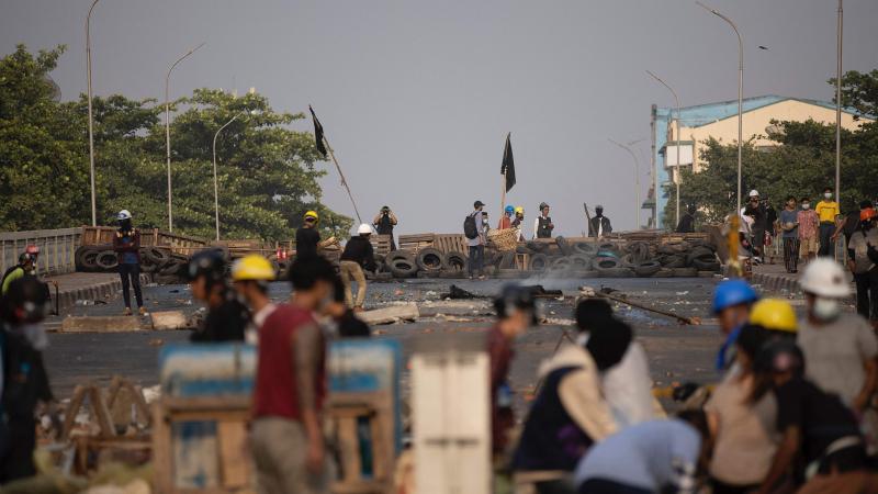 Protesters in Yangon, Myanmar, stand near makeshift barricades during demonstrations against the country's military coup. Protesters in Yangon, Myanmar, stand near makeshift barricades during demonstrations against the country's military coup.