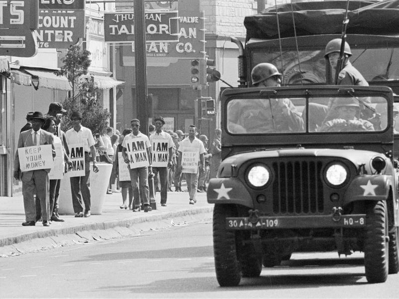 Tennessee National Guard troopers in jeeps and trucks escort a protest march by striking sanitation workers through downtown Memphis, March 30, 1968. Tennessee National Guard troopers in jeeps and trucks escort a protest march by striking sanitation workers through downtown Memphis, March 30, 1968.