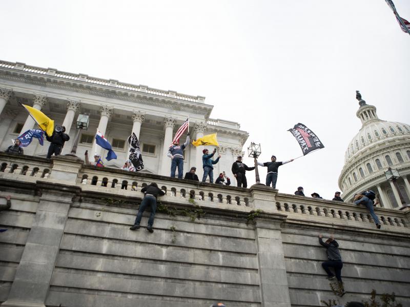 Supporters of former President Donald Trump climb the west wall of the the U.S. Capitol on Jan. 6. A New York man who was not at the riot is on trial for allegedly threatening to kill members of Congress in media posts supportive of the assault. Supporters of former President Donald Trump climb the west wall of the the U.S. Capitol on Jan. 6. A New York man who was not at the riot is on trial for allegedly threatening to kill members of Congress in media posts supportive of the assault.