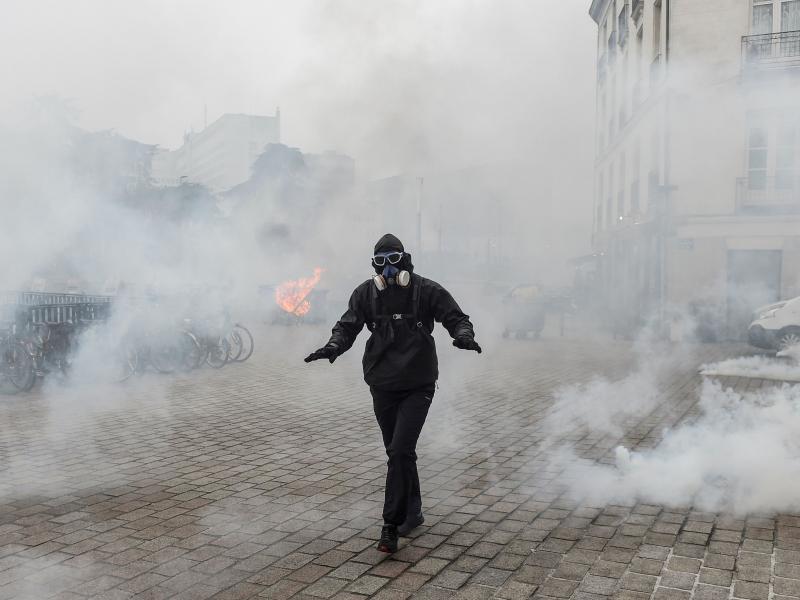 A protester walks through a cloud of tear gas during a demonstration against national pension changes in Nantes, France, on Thursday. A protester walks through a cloud of tear gas during a demonstration against national pension changes in Nantes, France, on Thursday.