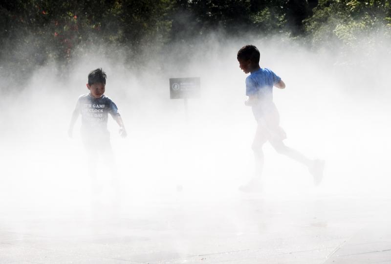 Children beat the heat Thursday in a misting pool at a park in Queens as temperatures reach into the 90s in New York City. Children beat the heat Thursday in a misting pool at a park in Queens as temperatures reach into the 90s in New York City.