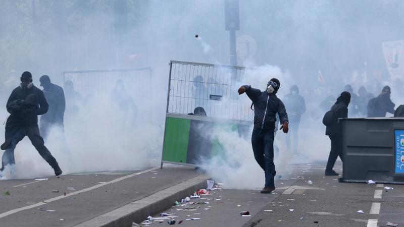 Masked protesters throw stones during clashes with French CRS riot forces at the May Day in Paris. Masked protesters throw stones during clashes with French CRS riot forces at the May Day in Paris.