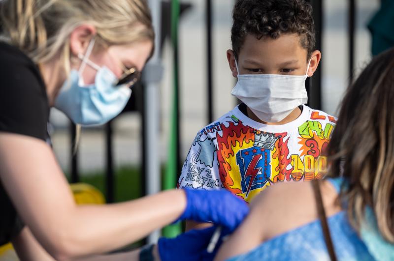 A child watches as a nurse administers a COVID-19 vaccine during a pop-up vaccination event in April at Lynn Family Stadium in Louisville, Ky. A child watches as a nurse administers a COVID-19 vaccine during a pop-up vaccination event in April at Lynn Family Stadium in Louisville, Ky.