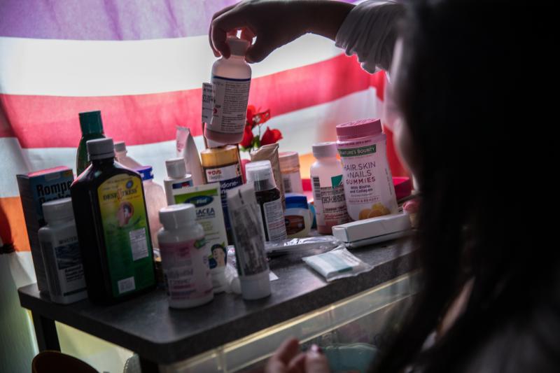 A woman recovering from fever linked to COVID-19 checks medications in her home in Mineola, N.Y., this spring. A woman recovering from fever linked to COVID-19 checks medications in her home in Mineola, N.Y., this spring.