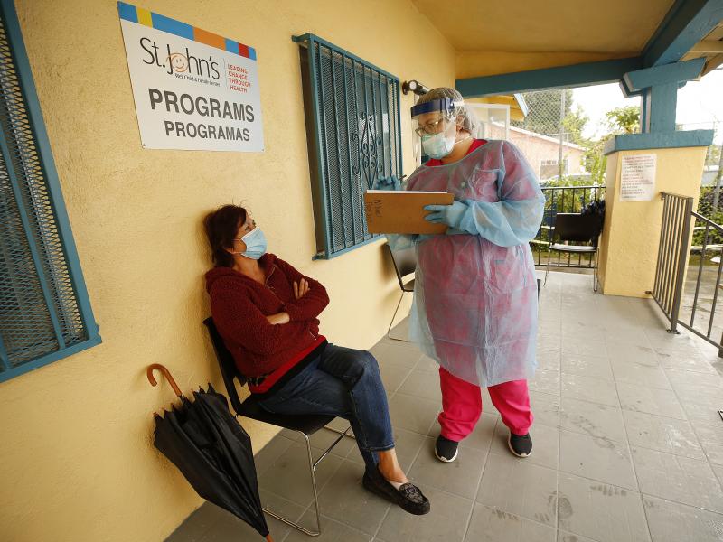 Maria Banderas, left, answers questions from medical assistant Dolores Becerra on May 18 before getting a coronavirus test at St. Johns Well Child and Family Center in South Los Angeles, one of the LA neighborhoods hit hard by COVID-19. Maria Banderas, left, answers questions from medical assistant Dolores Becerra on May 18 before getting a coronavirus test at St. Johns Well Child and Family Center in South Los Angeles, one of the LA neighborhoods hit hard by COVID-19.