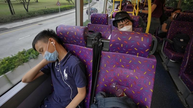 Passengers sleep on the upper deck of a double-decker bus in Hong Kong on Saturday. Passengers sleep on the upper deck of a double-decker bus in Hong Kong on Saturday.