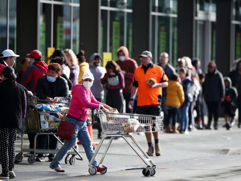 People line up outside a supermarket in a suburb of Auckland, New Zealand, on Wednesday before a three-day lockdown goes into effect. Four new COVID-19 cases were diagnosed in Auckland, and an additional four probable cases have been identified. People line up outside a supermarket in a suburb of Auckland, New Zealand, on Wednesday before a three-day lockdown goes into effect. Four new COVID-19 cases were diagnosed in Auckland, and an additional four probable cases have been identified.