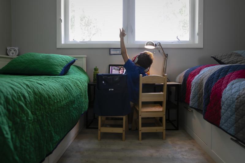 A student raises his hand while attending an online class from home in Miami on Sept. 3. A student raises his hand while attending an online class from home in Miami on Sept. 3.