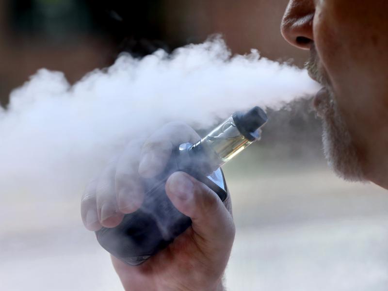 A man exhales while smoking an e-cigarette. New York Gov. Andrew Cuomo said the state will issue an emergency regulation banning certain flavored products amid a health scare linked to vaping. A man exhales while smoking an e-cigarette. New York Gov. Andrew Cuomo said the state will issue an emergency regulation banning certain flavored products amid a health scare linked to vaping.
