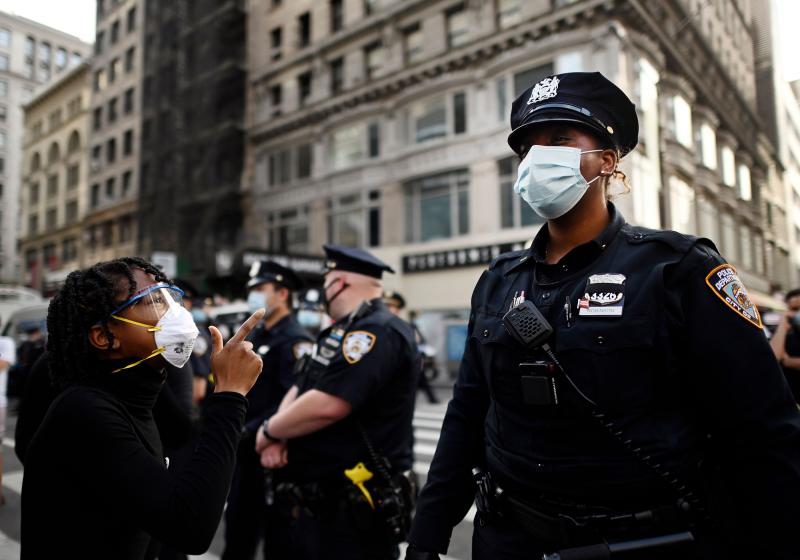Shouting protesters face NYPD officers during a Black Lives Matter demonstration last summer in New York City, in outrage over the death of a Black man in Minnesota who died after a white policeman knelt on his neck for several minutes. Shouting protesters face NYPD officers during a Black Lives Matter demonstration last summer in New York City, in outrage over the death of a Black man in Minnesota who died after a white policeman knelt on his neck for several minutes.