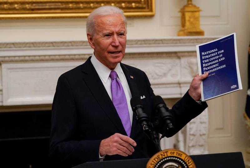 President Joe Biden holds a booklet as he speaks about the coronavirus in the State Dining Room of the White House, Thursday. President Joe Biden holds a booklet as he speaks about the coronavirus in the State Dining Room of the White House, Thursday.