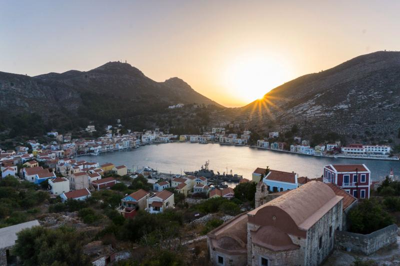 The Greek island of Kastellorizo, shown here at sunset from the top of an ancient castle, is a little over a mile away from the Turkish shore. Known for its architecture, turquoise sea and friendship with the neighbor Turks, it's recently become a pawn in The Greek island of Kastellorizo, shown here at sunset from the top of an ancient castle, is a little over a mile away from the Turkish shore. Known for its architecture, turquoise sea and friendship with the neighbor Turks, it's recently become a pawn in