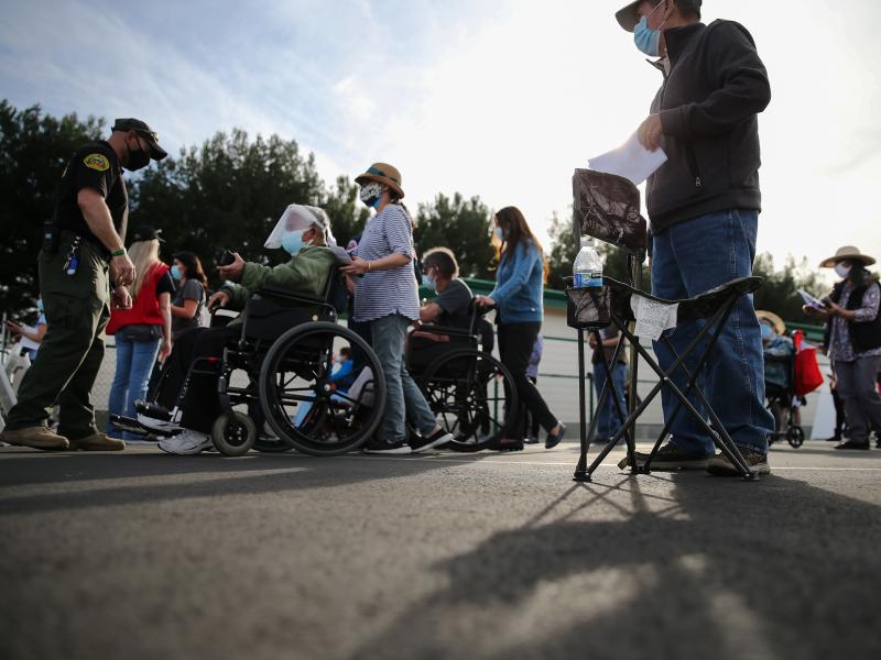 People lined up to receive the COVID-19 vaccine at a mass vaccination site in Disneyland's parking lot in Anaheim, Calif. on Jan. 13. The state says all residents 65 or older are now eligible to receive the vaccine. People lined up to receive the COVID-19 vaccine at a mass vaccination site in Disneyland's parking lot in Anaheim, Calif. on Jan. 13. The state says all residents 65 or older are now eligible to receive the vaccine.