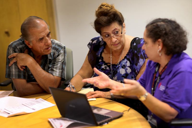 Affordable Care Act navigator Nini Hadwen (right) helped Jorge Hernandez (left) and Marta Aguirre find a plan on the health insurance exchange in Miami in 2013. Today, with fewer navigators, much of that counseling is done by phone instead of in person. Affordable Care Act navigator Nini Hadwen (right) helped Jorge Hernandez (left) and Marta Aguirre find a plan on the health insurance exchange in Miami in 2013. Today, with fewer navigators, much of that counseling is done by phone instead of in person.