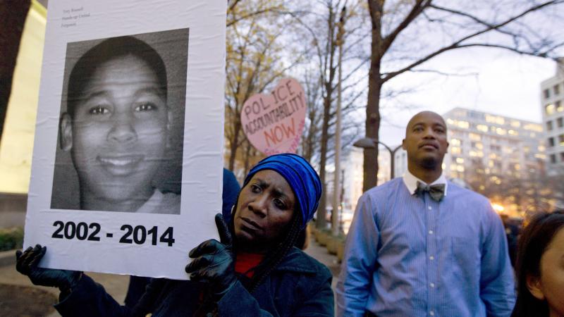 Tomiko Shine holds up a picture of Tamir Rice during a 2014 protest in Washington, D.C. Timothy Loehmann, the police officer who shot and killed the 12-year-old boy, was fired Tuesday for answers he provided on his personal history statement during the hi Tomiko Shine holds up a picture of Tamir Rice during a 2014 protest in Washington, D.C. Timothy Loehmann, the police officer who shot and killed the 12-year-old boy, was fired Tuesday for answers he provided on his personal history statement during the hi