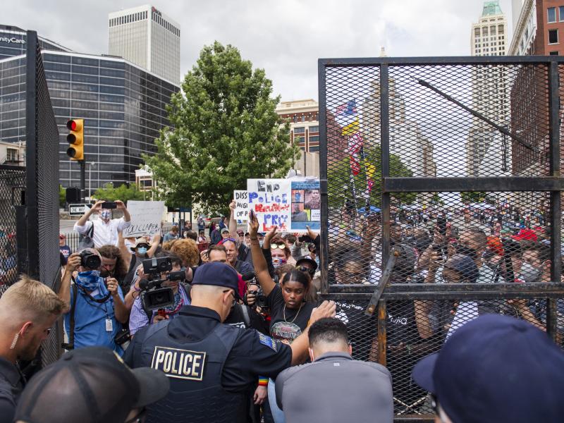 Protesters gather outside the entrance to a rally for then-President Donald Trump in June in Tulsa, Okla. A new state law increases penalties for protesters who block public roadways and grants legal immunity to drivers who unintentionally harm them as th Protesters gather outside the entrance to a rally for then-President Donald Trump in June in Tulsa, Okla. A new state law increases penalties for protesters who block public roadways and grants legal immunity to drivers who unintentionally harm them as th