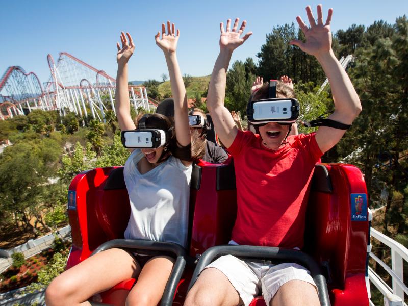 At Six Flags Magic Mountain in Valencia, Calif., riders of the New Revolution Virtual Reality Coaster wear VR goggles to play a video game while the roller coaster twists and turns. At Six Flags Magic Mountain in Valencia, Calif., riders of the New Revolution Virtual Reality Coaster wear VR goggles to play a video game while the roller coaster twists and turns.
