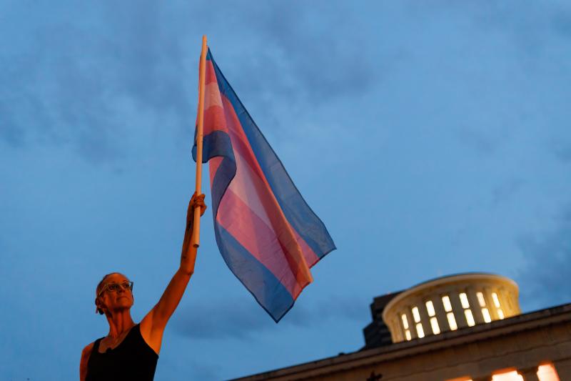 Cole Ramsey, 39, of South Linden, Ohio, holds a Transgender Pride Flag in front of the Ohio Statehouse in Columbus to protest the passing of legislation against trans women playing sports in high school and college. Cole Ramsey, 39, of South Linden, Ohio, holds a Transgender Pride Flag in front of the Ohio Statehouse in Columbus to protest the passing of legislation against trans women playing sports in high school and college.