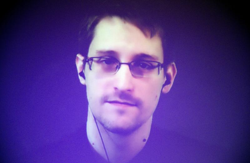 Edward Snowden appears from Russia on a giant video screen in 2014. The former National Security Agency contractor fled to Russia in 2013 shortly after leaking information about the NSA's bulk data collection program. He also faces charges in the U.S. und Edward Snowden appears from Russia on a giant video screen in 2014. The former National Security Agency contractor fled to Russia in 2013 shortly after leaking information about the NSA's bulk data collection program. He also faces charges in the U.S. und